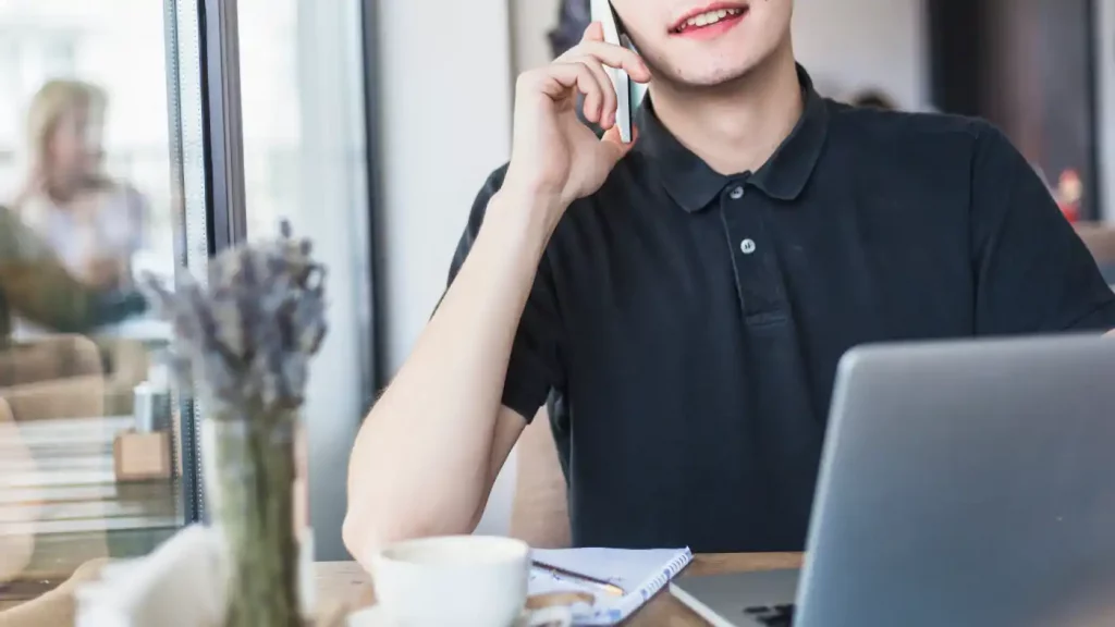 man talking by phone table cafe
